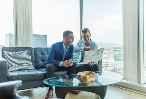 Two people on sofa looking at laptop